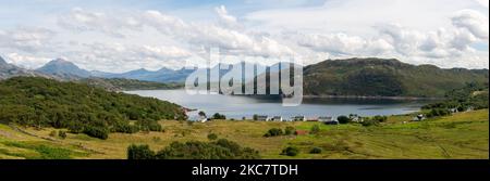 Acqua circondata da cottage bianchi e verdi montagne coperte di erba, soleggiato, cielo blu e nuvole in estate tempo, paesaggio sereno con fermo, smoot Foto Stock