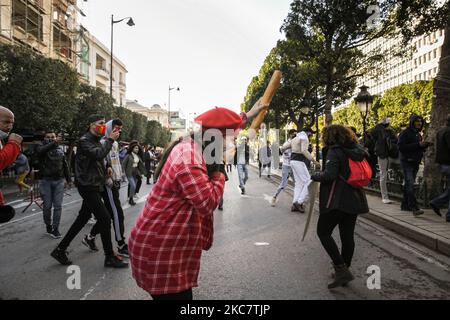 Una giovane protesta femminile solleva un pane soffocato dallo spray al pepe usato dalle forze di sicurezza durante una manifestazione anti-governativa tenutasi su Avenue Habib Bourguiba, nella capitale Tunisi, in Tunisia, il 19 gennaio 2021, Per protestare contro il governo del primo ministro Hichem Mechichi, e a sostegno dei movimenti di protesta che hanno colpito la Tunisia in diverse città durante la notte degli ultimi giorni. I manifestanti si scontrarono con le forze di sicurezza che spararono gas lacrimogeni e usarono spray al pepe nel tentativo di disperderli. Hanno anche sostenuto la liberazione dei giovani arrestati dai poli Foto Stock