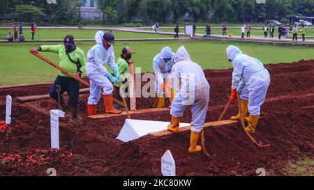 Un ufficiale funerario della città cammina attraverso un cimitero speciale per le sospette vittime di Covid-19 il 22 gennaio 2021 a Giacarta, Indonesia. Il governo indonesiano, specialmente a Giacarta, ha aperto nuove terre per i corpi dei passanti Covid-19 al cimitero pubblico di Bambu Apus (TPU), Jakarta, con una superficie di 3.000 metri quadrati (Foto di Edi Ismail/NurPhoto) Foto Stock