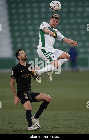 Raul Guti di Elche e Sergio Busquets di Barcellona si sfidano per la palla durante la partita la Liga Santander tra Elche CF e FC Barcelona a Estadio Martinez Valero il 24 gennaio 2021 a Elche, Spagna. Gli stadi sportivi in Spagna restano soggetti a rigorose restrizioni a causa del Coronavirus Pandemic, in quanto le leggi di allontanamento sociale del governo vietano ai fan all'interno dei locali, con conseguente gioco a porte chiuse. (Foto di Jose Breton/Pics Action/NurPhoto) Foto Stock