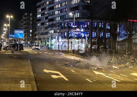 Blocco stradale fatto di biciclette mentre le seppellire. Le conseguenze della protesta contro il blocco devastano il centro di Eindhoven, nei Paesi Bassi. Il secondo giorno del rigido Coronavirus Covid-19 misure di blocco con un coprifuoco imposto tra il 21:00 e il 04:30 dal governo olandese dal 23 gennaio 2021, per combattere la diffusione della pandemia e la nuova mutazione. Centinaia di manifestanti si sono scontrati con la polizia in un raduno contro le nuove regole. La manifestazione ha provocato rivolte, saccheggi e danni ai negozi, finestre rotte e danni alla stazione ferroviaria, l'incendio di ProRail Foto Stock