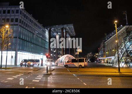 Veicoli della polizia che soggiornano al 18 settembre in una delle piazze centrali della città dopo gli scontri. Le conseguenze della protesta contro il blocco devastano il centro di Eindhoven, nei Paesi Bassi. Il secondo giorno del rigido Coronavirus Covid-19 misure di blocco con un coprifuoco imposto tra il 21:00 e il 04:30 dal governo olandese dal 23 gennaio 2021, per combattere la diffusione della pandemia e la nuova mutazione. Centinaia di manifestanti si sono scontrati con la polizia in un raduno contro le nuove regole. La manifestazione ha portato a rivolte, saccheggi e danneggiare negozi, finestre rotte e da Foto Stock