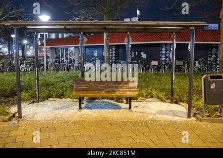 Una fermata dell'autobus danneggiata vicino alla stazione ferroviaria. Le conseguenze della protesta contro il blocco devastano il centro di Eindhoven, nei Paesi Bassi. Il secondo giorno del rigido Coronavirus Covid-19 misure di blocco con un coprifuoco imposto tra il 21:00 e il 04:30 dal governo olandese dal 23 gennaio 2021, per combattere la diffusione della pandemia e la nuova mutazione. Centinaia di manifestanti si sono scontrati con la polizia in un raduno contro le nuove regole. La manifestazione ha provocato rivolte, saccheggi e danni ai negozi, rottura delle finestre e danni alla stazione ferroviaria, incendio di un'auto ProRail, Foto Stock