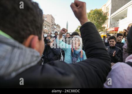 I manifestanti sollevano i pugni mentre glano slogan anti-governativi durante una marcia di protesta iniziata nel quartiere popolare e duro di Hay Ettadhamen, una delle città più popolate di Tunisi, E si dirigono verso la città di Bardo a Tunisi, per protestare contro la brutalità della polizia, l'emarginazione e la crisi economica e sociale del paese. I manifestanti avevano anche chiesto il rilascio di giovani arrestati dalla polizia durante le ultime proteste notturne, dove si erano scontrati con le forze di sicurezza. Le forze di sicurezza hanno impedito loro di dimostrare di fronte alla costruzione di t Foto Stock