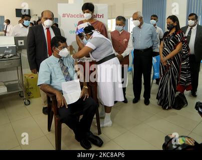 Il medico consulente dello Sri Lanka Dr. Ananda Wijewickrema (L) riceve la prima dose di vaccino Oxford-AstraZeneca COVID-19 sparato come ministro dello Stato dello Sri Lanka per i servizi sanitari primari, le pandemie e la prevenzione della COVID Dr. Sudarshini Fernandopulle, Alto commissario dell'India Gopal Baglay e consulente del presidente Gotabaya Rajapaksa, Lalith Weeratunga guardare al National Institute of Infectious Diseases Hospital di Colombo, Sri Lanka, 29 gennaio 2021. Lo Sri Lanka venerdì (29) ha avviato la sua campagna nazionale di immunizzazione contro il coronavirus somministrando i primi shot agli operatori sanitari di prima linea, Foto Stock