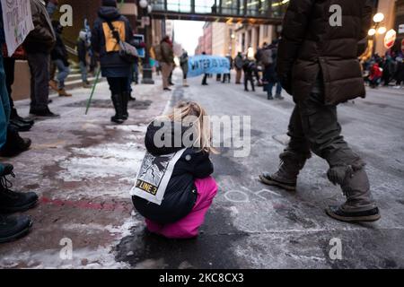 Un bambino ascolta gli oratori durante una protesta contro il gasdotto Enbridge Line 3. St. Paul, Minnesota. Gennaio 29, 2021. Quasi 600 attivisti e protettori d'acqua hanno partecipato a una protesta contro l'oleodotto Enbridge Line 3 venerdì sera a St. Paul, Minnesota. L'evento è stato organizzato da oltre una dozzina di gruppi, tra cui Sunrise Movement MN, Honor the Earth, International Indigenous Youth Council, Environment MN, MN350 e altri. I partecipanti hanno chiesto al governatore Tim Walz e alla Army Corp of Engineers di revocare il permesso del gasdotto anche per motivi umanitari e di sicurezza ambientale Foto Stock