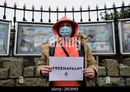 Un manifestante che indossa una maschera facciale contiene un poster "Navalny libero" durante un raduno simbolico a sostegno del leader dell'opposizione russo Alexei Navalny imprigionato di fronte all'ambasciata russa a Dublino. Domenica 31 gennaio 2021 a Dublino, Irlanda. (Foto di Artur Widak/NurPhoto) Foto Stock