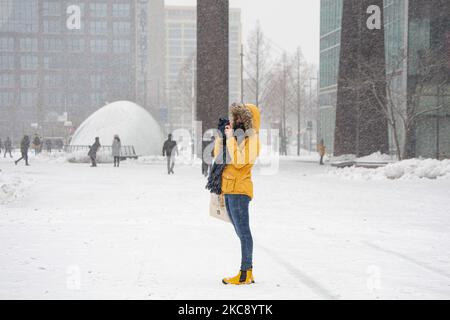 Una giovane donna con una giacca gialla fotografa la neve coperta di piazza 18 Septemberplein. Blizzard dalla tempesta di neve Darcy nei Paesi Bassi, la prima nevicata pesante con forti venti intensi dopo 2010 che ha interrotto il trasporto in tutto il paese. I olandesi si svegliarono la domenica con uno strato di neve che copriva tutto. Molti incidenti si sono verificati sulle strade a causa della tempesta e delle condizioni ghiacciate, mentre c'era un problema anche con i treni. Nella città di Eindhoven, nel Brabante settentrionale, i servizi ferroviari e di autobus cessarono di funzionare, l'aeroporto seguì e il traffico aereo fu deviato. La gente è andata tu Foto Stock