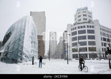 Si vedono le persone in bicicletta sulla neve nel centro di Eindhoven, coperto di neve, nel 18 Settemberplein. Blizzard dalla tempesta di neve Darcy nei Paesi Bassi, la prima nevicata pesante con forti venti intensi dopo 2010 che ha interrotto il trasporto in tutto il paese. I olandesi si svegliarono la domenica con uno strato di neve che copriva tutto. Molti incidenti si sono verificati sulle strade a causa della tempesta e delle condizioni ghiacciate, mentre c'era un problema anche con i treni. Nella città di Eindhoven, nel Brabante settentrionale, i servizi ferroviari e di autobus cessarono di funzionare, l'aeroporto seguì e il traffico aereo fu deviato Foto Stock