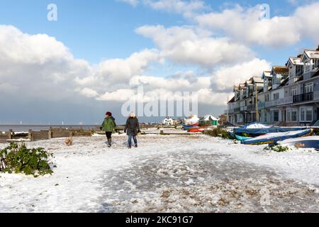 Si vedono persone che camminano su una spiaggia in una soleggiata giornata invernale tra vento e neve nella costa sud-orientale dell'Inghilterra dopo insolite temperature di congelamento hanno colpito la zona - 9 febbraio 2021 a Whitstable, Inghilterra. (Foto di Dominika Zarzycka/NurPhoto) Foto Stock