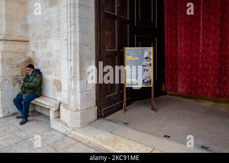 Un fedele seduto fuori dalla Cattedrale di Molfetta, prima dell'inizio della celebrazione della Messa, il 9 febbraio 2021 a Molfetta. Il 9 febbraio è la festa liturgica dedicata a San Corrado, patrono della Molfetta. In questa data la Chiesa ricorda il giorno in cui, secondo la tradizione, le reliquie del Santo furono trasferite da Modugno, luogo della sua morte, a Molfetta. La festa di San Corrado quest'anno, per ovvie ragioni legate all'attuale emergenza sanitaria, era priva di celebrazioni che avevano visto la comunità cittadina riunirsi intorno alla tradizionale illuminazione dei falò b Foto Stock