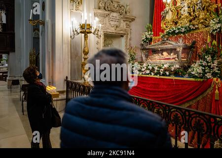 Si prega davanti alla statua e alle reliquie di San Corrado nella Cattedrale di Molfetta il 9 febbraio 2021 a Molfetta. Il 9 febbraio è la festa liturgica dedicata a San Corrado, patrono della Molfetta. In questa data la Chiesa ricorda il giorno in cui, secondo la tradizione, le reliquie del Santo furono trasferite da Modugno, luogo della sua morte, a Molfetta. La festa di San Corrado quest'anno, per ovvie ragioni legate all'attuale emergenza sanitaria, era priva di celebrazioni che avevano visto la comunità cittadina riunirsi intorno alla tradizionale illuminazione dei falò ma solo re Foto Stock