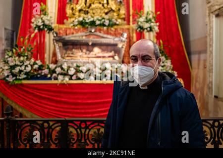 Il parroco Don Vito Bufi posa per un ritratto, davanti alla statua e alle reliquie di San Corrado, il 9 febbraio 2021 a Molfetta. Il 9 febbraio è la festa liturgica dedicata a San Corrado, patrono della Molfetta. In questa data la Chiesa ricorda il giorno in cui, secondo la tradizione, le reliquie del Santo furono trasferite da Modugno, luogo della sua morte, a Molfetta. La festa di San Corrado quest'anno, per ovvie ragioni legate all'attuale emergenza sanitaria, era priva di celebrazioni che avevano visto la comunità cittadina riunirsi intorno all'illuminazione tradizionale di bonfi Foto Stock