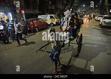 Un estrattore di risciò trasporta i suoi passeggeri con la dea Saraswati a Kolkata, 15 febbraio 2021. Il Basant Panchami, che si celebrerà il 16 febbraio di quest'anno, segna l'avvento della primavera. (Foto di Indranil Aditya/NurPhoto) Foto Stock