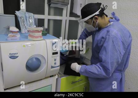 Ayax Malacate, chirurgo dentale, nel processo di sviluppo di una radiografia durante l'emergenza sanitaria e il semaforo epidemiologico arancione, presso la sua clinica situata a Colonia Las Arboledas Tláhuac, Città del Messico. Prima dell'inizio della vaccinazione contro il COVID-19 in Messico, l'Unione dentale ha lanciato una campagna per rendere visibile la necessità di essere considerati nella prima fase del piano nazionale di vaccinazione, poiché nella loro pratica professionale quotidiana sono a rischio di essere infettati con coronavirus da essere in contatto diretto con la bocca e la saliva dei vostri pazienti. Sostengono che le goccioline di saliva A. Foto Stock