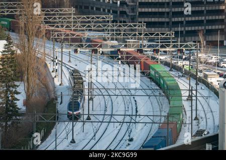 Un carico e un treno passeggeri sulle piste innevate nel centro della città. Panoramica della città olandese innevata di Eindhoven come si vede nel centro e nelle zone residenziali, mentre la neve copriva le strade, la ferrovia, i tetti per un periodo di oltre una settimana, con conseguente congelamento anche dei laghi e dei canali. Eindhoven, Paesi Bassi il 2021 febbraio (Foto di Nicolas Economou/NurPhoto) Foto Stock