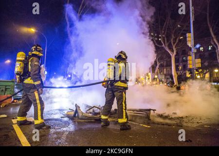 Il vigile del fuoco ha visto mettere fuori fuoco contenitori di rifiuti seconda notte di manifestazioni, a Barcellona, per la prigione del rapper catalano, Pablo Hasél, arrestato martedì 16 febbraio e condannato a nove mesi e un giorno di carcere dalla Camera d'appello della Corte Nazionale nel settembre 2018, oltre al pagamento di una multa di circa 30.000 euro accusati di glorificare il terrorismo, insultare e calunniare la monarchia e le forze di sicurezza dello stato. (Foto di DAX Images/NurPhoto) Foto Stock