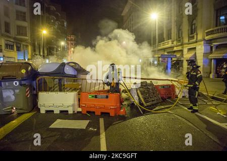 Il vigile del fuoco ha visto mettere fuori fuoco contenitori di rifiuti seconda notte di manifestazioni, a Barcellona, per la prigione del rapper catalano, Pablo Hasél, arrestato martedì 16 febbraio e condannato a nove mesi e un giorno di carcere dalla Camera d'appello della Corte Nazionale nel settembre 2018, oltre al pagamento di una multa di circa 30.000 euro accusati di glorificare il terrorismo, insultare e calunniare la monarchia e le forze di sicurezza dello stato. (Foto di DAX Images/NurPhoto) Foto Stock