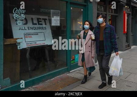 Gli acquirenti che indossano maschere facciali camminano per le strade di Westminster a Londra il 19 febbraio 2021. (Foto di Giannis Alexopoulos/NurPhoto) Foto Stock