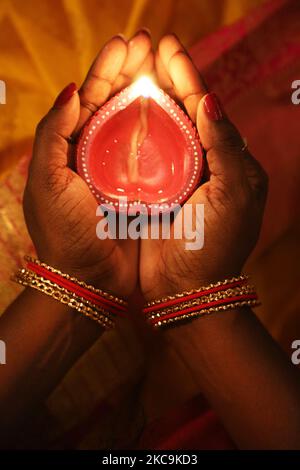 Il devoto indù tiene un diya (piccola lampada di argilla) durante il festival di Diwali in un tempio indù a Toronto, Ontario, Canada, il 14 novembre 2020. (Foto di Creative Touch Imaging Ltd./NurPhoto) Foto Stock