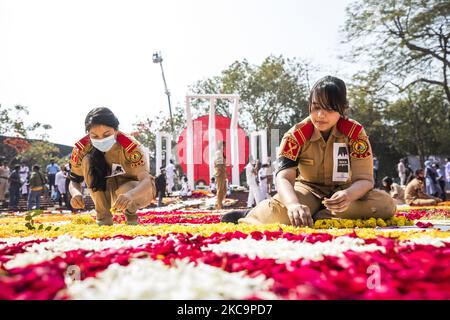 I giovani decorano con fiori il monumento commemorativo dei martiri della lingua centrale del Bangladesh in omaggio ai martiri del movimento linguistico bengalese del 1952 durante la Giornata Internazionale della lingua madre, a Dhaka il 21 febbraio 2021. Questo evento è dedicato ai martiri che sono morti il 21 febbraio 1952 in una manifestazione che chiede l'istituzione del Bengalese come una delle lingue statali dell'ex Pakistan orientale. (Foto di Ahmed Salahuddin/NurPhoto) Foto Stock