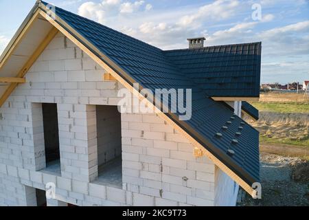 Vista aerea di casa incompiuta con pareti in calcestruzzo leggero aerato e telaio del tetto in legno rivestito con piastrelle metalliche in costruzione Foto Stock