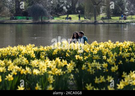 La gente passa davanti a un letto di fiori pieno di narcisi fiorenti nel St James's Park a Londra, il 26 febbraio 2021 a Londra, Inghilterra. (Foto di Wiktor Szymanowicz/NurPhoto) Foto Stock