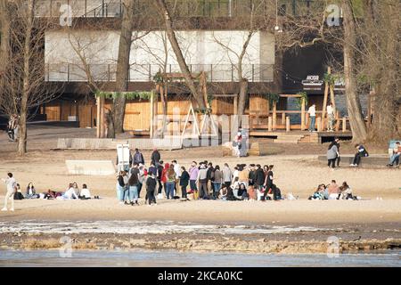 Le persone senza maschere si vedono riunite sulle rive del fiume Vistola a Varsavia, Polonia, il 25 febbraio 2021. Il governo di giovedì ha annunciato un cambiamento nelle regole che vieteranno l'uso di qualsiasi tipo di copertura facciale che non sia una maschera facciale adeguata. Mentre le temperature hanno raggiunto ben al di sopra di 10 gradi centigradi molti si riuniscono all'aperto senza maschere lungo le rive del fiume. (Foto di Jaap Arriens/NurPhoto) Foto Stock