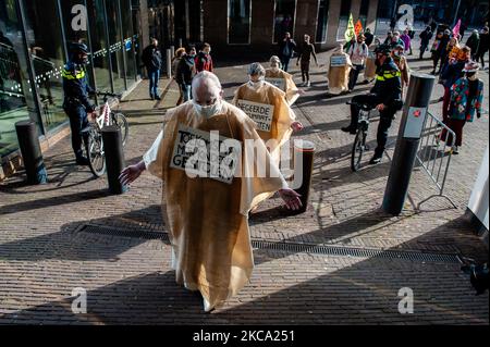 Un gruppo di attivisti del clima, che assomiglia a penitenti, cammina per le strade durante la protesta dei Penitenti organizzata da Extinction Rebellion, all'Aia, il 27th febbraio 2021. (Foto di Romy Arroyo Fernandez/NurPhoto) Foto Stock