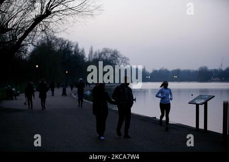 Una donna scherza accanto al lago serpentino di Hyde Park al tramonto a Londra, Inghilterra, il 2 marzo 2021. (Foto di David Cliff/NurPhoto) Foto Stock