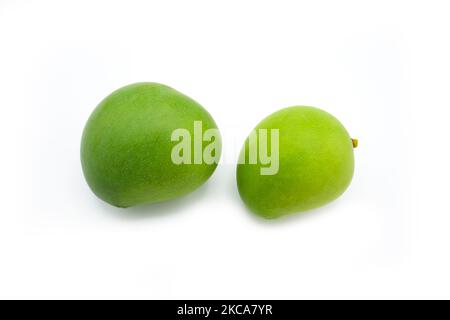 Due mango verdi immature isolati su sfondo bianco Foto Stock
