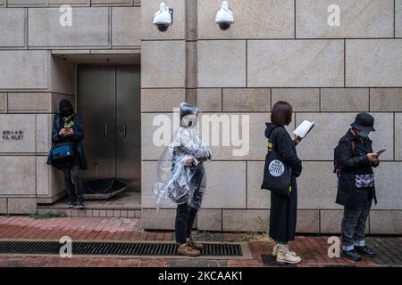 I sostenitori si trovano sotto due telecamere CCTV mentre attendono al di fuori dei tribunali dei Magistrati di Kowloon ad ovest durante un'audizione per 47 attivisti dell'opposizione accusati di aver violato la legge sulla sicurezza nazionale della città a Hong Kong, Cina, mercoledì 4 marzo 2021. Decine di attivisti a favore della democrazia sono ancora in attesa di scoprire se saranno liberati dalla prigione prima di essere processati con accuse di sovversione, mentre Pechino continua a portare avanti i piani di revisione del sistema elettorale degli hub finanziari. (Foto di Vernon Yuen/NurPhoto) Foto Stock