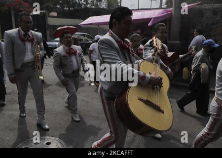 Un gruppo di mariachi ha serenato i parenti di una persona deceduta a Città del Messico, Che hanno effettuato una processione silenziosa nella zona di Coyoacán, portando la bara della loro amata prima di portarlo al cimitero di quartiere durante l'emergenza sanitaria COVID-19 e il semaforo epidemiologico arancione nella capitale. In alcune zone della città come Coyoacán, Iztapalapa, Xochimilco, Tláhuac e Milpa alta, gli usi e le usanze sono profondamente radicati. (Foto di Gerardo Vieyra/NurPhoto) Foto Stock