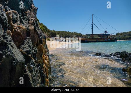 Navi pirata che trasportano turisti dall'altra parte della penisola. Aretes spiaggia nella zona di Toroni a Halkidiki. La spiaggia con la sabbia dorata e l'acqua cristallina smeraldo, tipica del Mar Egeo e del Mediterraneo, è composta da 3 diverse baie. La costa protetta da colline rocciose intorno è un tesoro nascosto per la gente del posto e i turisti senza le scene d'estate sovraffollate con i bar sulla spiaggia. Il CHALKIDIKI è una meta turistica molto popolare, famosa per le migliori spiagge del paese, a breve distanza in auto, vicino alla città di Salonicco. La Grecia sta spingendo per una vaccinazione COVID Foto Stock