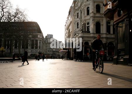 Un uomo guida una bicicletta a noleggio davanti a cinema chiusi, casinò e ristoranti in una vicina e deserta Leicester Square a Londra, Inghilterra, il 8 marzo 2021. Oggi ha segnato la prima fase dell’allentamento del blocco del coronavirus in tutta l’Inghilterra, con la riapertura delle scuole e l’allentamento di alcuni limiti sui contatti sociali. I negozi non essenziali, i bar, i ristoranti e le altre aziende di ospitalità rimangono comunque chiusi e riapriranno solo il mese prossimo secondo gli orari attuali. (Foto di David Cliff/NurPhoto) Foto Stock
