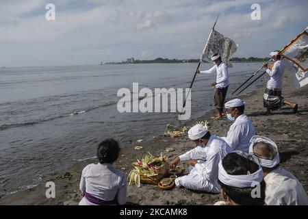 Indù balinese prega durante la cerimonia di purificazione chiamata Melasti in mezzo alla pandemia COVID-19 sulla spiaggia di Denpasar, Bali, Indonesia il 11 2021 marzo. La cerimonia ha lo scopo di pulire le anime prima di entrare nella Giornata del silenzio balinese, segna il nuovo anno nel calendario indù balinese che cade il 14 marzo. La cerimonia di solito ha partecipato a migliaia di devoti, ma durante la pandemia COVID-19 solo poche persone hanno permesso di partecipare alla processione. (Foto di Johanes Christo/NurPhoto) Foto Stock