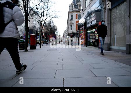 Un uomo che indossa una maschera facciale cammina lungo una Oxford Street quasi deserta a Londra, Inghilterra, il 11 marzo 2021. Questa settimana ha segnato la prima fase del lockdown easing del coronavirus in tutta l’Inghilterra, con la riapertura delle scuole e l’allentamento di alcuni limiti sui contatti sociali. I negozi non essenziali, i bar, i ristoranti e le altre aziende del settore alberghiero e del tempo libero rimangono tuttavia chiusi e riapriranno solo il mese prossimo secondo gli orari attuali. (Foto di David Cliff/NurPhoto) Foto Stock