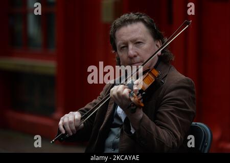 Esattamente un anno dalla chiusura della Temple Bar Area a causa della pandemia del COVID-19, il famosissimo fiddler Frankie Gavin si esibisce in un lamento nel quartiere culturale deserto di Dublino. Lunedì 15 marzo 2021 a Dublino, Irlanda. (Foto di Artur Widak/NurPhoto) Foto Stock