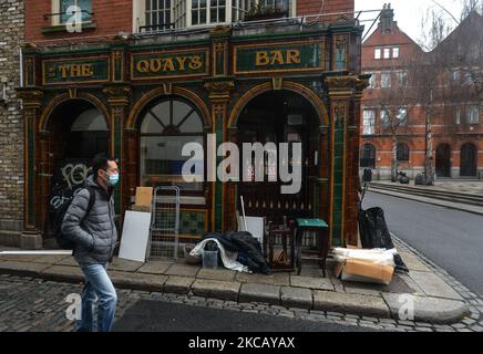 Un uomo che indossa una maschera facciale cammina in un pub chiuso in Temple Bar Square. Esattamente un anno dalla chiusura della Temple Bar a causa della pandemia del COVID-19. Lunedì 15 marzo 2021 a Dublino, Irlanda. (Foto di Artur Widak/NurPhoto) Foto Stock