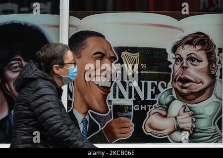 Una donna che indossa una maschera facciale cammina in un pub chiuso nel centro della città di Dublino durante il blocco di livello 5 Covid-19. Lunedì 15 marzo 2021 a Dublino, Irlanda. (Foto di Artur Widak/NurPhoto) Foto Stock