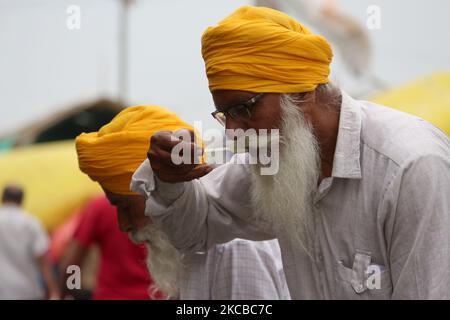 Gli agricoltori mangiano pasti langari durante la protesta in corso contro le recenti riforme agricole mentre si riuniscono per celebrare l'anniversario della morte dei combattenti indiani per la libertà Bhagat Singh, Rajguru e Sukhdev, al confine Delhi-Uttttar Pradesh vicino Ghazipur, alla periferia di Nuova Delhi, India il 23 marzo 2021. (Foto di Mayank Makhija/NurPhoto) Foto Stock