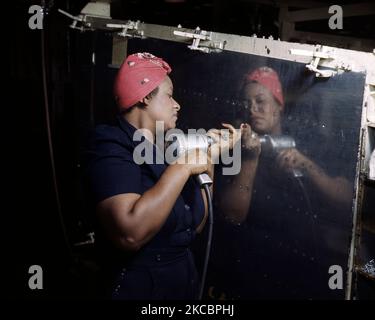 Lavoratrice di fabbrica che utilizza un trapano a mano su un Bombardiere subacqueo A-31 Vengeance durante la seconda guerra mondiale, 1943. Foto Stock