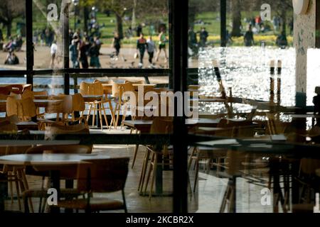 Tavoli vuoti sono visti nell'area interna di un cafè temporaneamente chiuso accanto al lago Serpentine a Hyde Park a Londra, Inghilterra, il 29 marzo 2021. Le restrizioni di blocco sono state allentate in tutta l'Inghilterra oggi, con la regola della "casa di riposo" terminata, gruppi di fino a sei ha permesso di incontrarsi all'aperto, sport all'aperto riavviato e matrimoni con fino a sei persone che partecipano permesso a Passi pure. Negozi, ospitalità e attività ricreative rimangono comunque chiusi, con il prossimo allentamento delle restrizioni non previsto prima del 12 aprile. L'alleggerimento di oggi ha coinciso nel frattempo con il primo di un 'mini-heat' di tre giorni Foto Stock