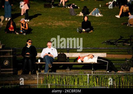 La gente si rilassa sotto il caldo sole primaverile accanto ai Giardini Italiani di Kensington Gardens a Londra, in Inghilterra, il 29 marzo 2021. Le restrizioni di blocco sono state allentate in tutta l'Inghilterra oggi, con la regola della "casa di riposo" terminata, gruppi di fino a sei ha permesso di incontrarsi all'aperto, sport all'aperto riavviato e matrimoni con fino a sei persone che partecipano permesso a Passi pure. Negozi, ospitalità e attività ricreative rimangono comunque chiusi, con il prossimo allentamento delle restrizioni non previsto prima del 12 aprile. L'alleggerimento di oggi ha coinciso nel frattempo con il primo di un'onda mini-termica di tre giorni, con la temperatura diurna Foto Stock