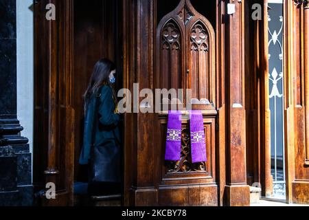Una donna partecipa alla confessione all'interno della Basilica della Santissima Trinità durante la pandemia di coronavirus a Cracovia, in Polonia, il 1 aprile 2021. (Foto di Beata Zawrzel/NurPhoto) Foto Stock