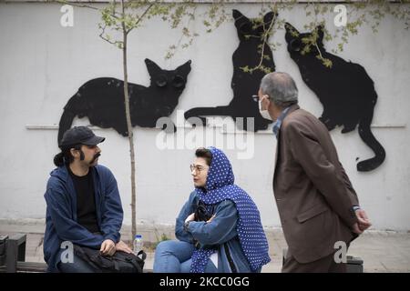 Un uomo iraniano e una donna si parlano tra loro mentre si siedono fuori dal Museo del Cinema nel nord di Teheran durante il giorno di Sizdah Bedar, noto anche come Giornata della natura, il 2 aprile 2021. Il Sizdah Bedar, noto anche come Nature’s Day, è un festival iraniano che si tiene ogni anno il tredicesimo giorno di Farvardin (il primo mese del calendario iraniano), dove le persone trascorrono del tempo all’aperto e segnano la fine delle vacanze a Nowruz in Iran. Ma il governo iraniano ha chiuso i parchi e ha chiesto alla gente di rimanere nelle loro case per proteggersi e gli altri contro la nuova epidemia di coronavirus (COVID-19). (PH Foto Stock