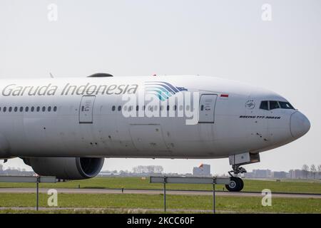 Vicino a piloti, capitano, primo ufficiale e equipaggio di cabina sono visti all'interno di un abitacolo Boeing 777 indossando maschere mediche come misura di sicurezza contro la diffusione di Covid. Il Boeing 777-300 di Garuda Indonesia sta tassando in aeroporto Schiphol di Amsterdam AMS per la partenza per Giacarta. Il numero di traffico mondiale di passeggeri nel settore dell'aviazione è diminuito a causa delle restrizioni sui viaggi, delle misure di sicurezza come blocchi, quarantena, ecc. durante l'era della pandemia di Coronavirus del Covid-19 che ha colpito duramente l'industria dell'aviazione e dei viaggi. Amsterdam, Paesi Bassi il 1 aprile 2021 (Foto di Nicolas Economou/NurPhoto) Foto Stock