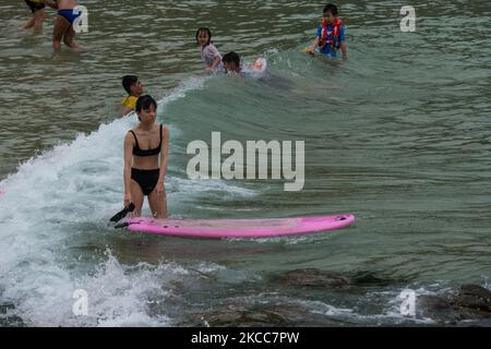 Un surfista porta la sua tavola a Big Wave Bay, una spiaggia situata sull'isola di Hong Kong a Hong Kong, Cina, il 3 aprile 2021. (Foto di Marc Fernandes/NurPhoto) Foto Stock