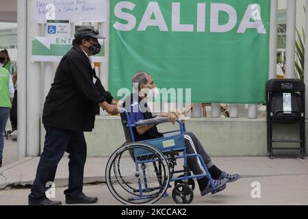 Un operaio del governo di Città del Messico assiste una donna anziana in una sedia a rotelle da Iztapalapa, che è andato all'ospedale militare El Vergel per essere immunizzato con il Sputnik V biologico contro COVID-19 durante l'emergenza sanitaria e il semaforo epidemiologico arancione nella capitale. (Foto di Gerardo Vieyra/NurPhoto) Foto Stock