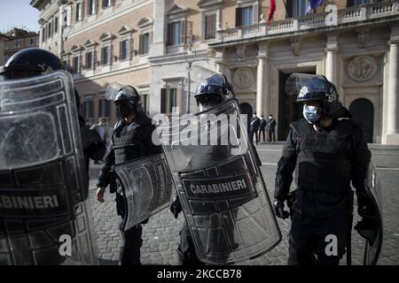 Poliziotti anti-tumulto prendono posizione durante una manifestazione di proprietari di ristoranti, imprenditori e piccoli imprenditori il 6 aprile 2021 fuori dal parlamento su Piazza Montecitorio a Roma, per chiedere il riavvio delle attività costrette a fermarsi a causa delle restrizioni del Covid-19 (Foto di Christian Minelli/NurPhoto) Foto Stock